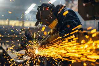 Metal Worker Using Grinder