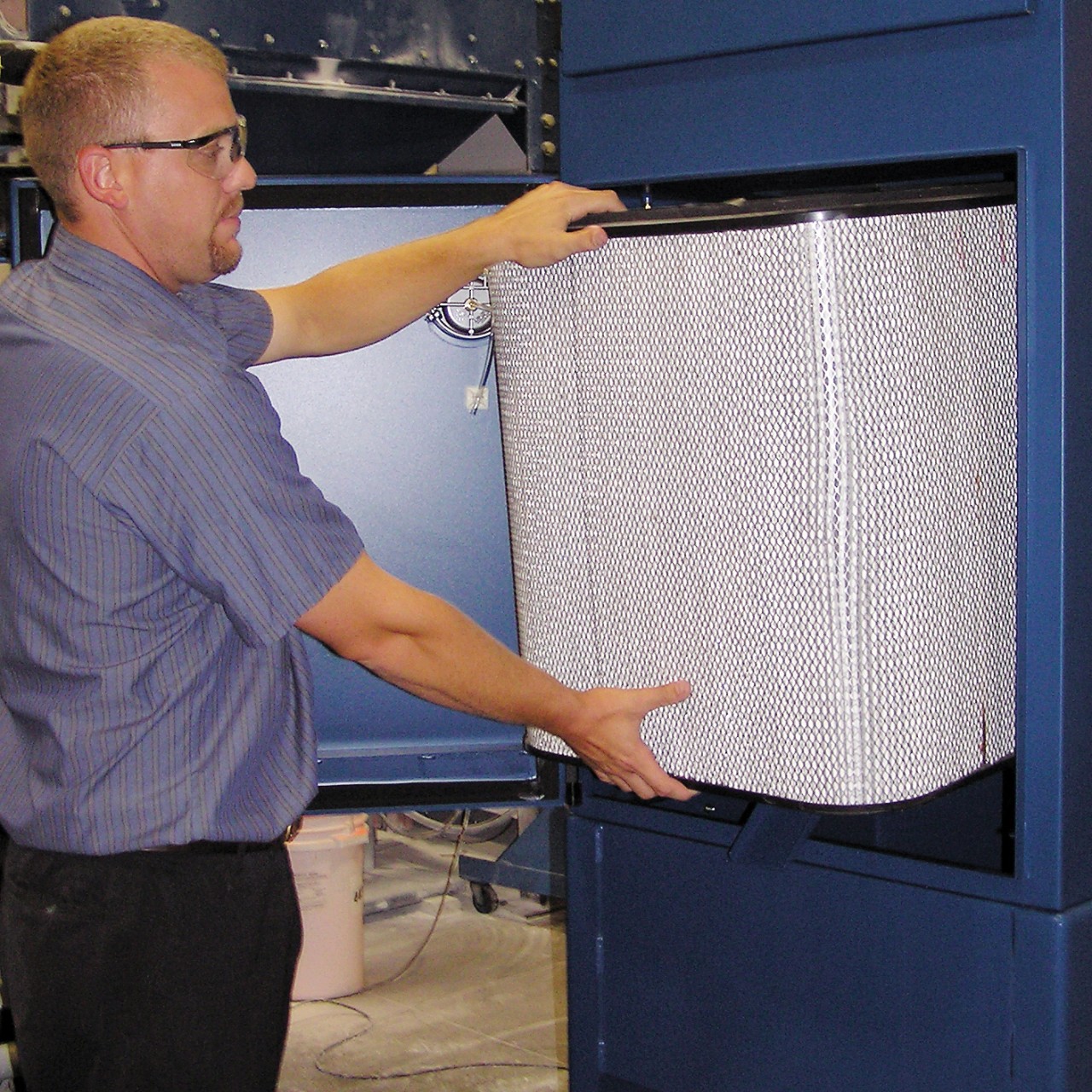 A man changes a WSO Mist Collector Filter